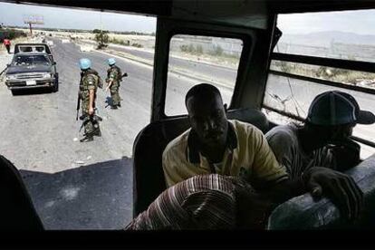 Dos <i>cascos azules</i> de la ONU revisan los vehículos en un control a las afueras de Puerto Príncipe.