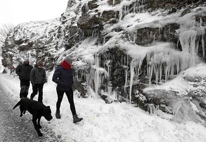 Un grupo de jóvenes, junto con su perro pasean por la N-718 en el alto de Urbasa donde las bajas temperaturas de estos días han propiciado la formación de carámbanos de hielo junto a la carretera.