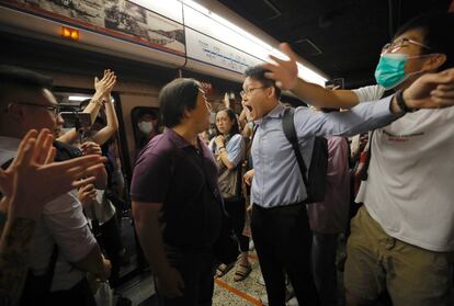 Pasajeros y manifestantes discuten durante una protesta que irrumpió este martes las líneas del metro en Hong Kong. Los activistas en favor de la democracia que desde hace ocho semanas se manifiestan en Hong Kong llevaron su campaña al subsuelo y bloquearon las puertas de los trenes, provocando retrasos en el transporte suburbano durante las horas punta.