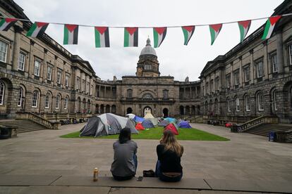 Dos estudiantes permanecen sentados frente al campamento propalestino establecido en la Universidad de Edimburgo, este miércoles 8 de mayo.