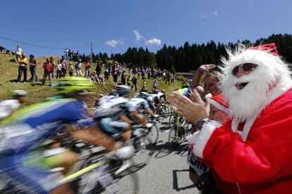 Un aficionado disfrazado de Papa Noel aplaude al paso del pelotón.