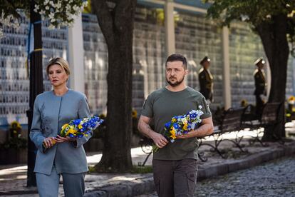 This handout photo taken and released by the Ukrainian presidential press service on August 24, 2022, shows Ukrainian President Volodymyr Zelensky (R) and his wife Olena attending a commemoration ceremony at a memorial wall displaying images of Ukrainian servicemen and servicewomen killed since Russia launched a military invasion on the country in February, in the centre of Kyiv, on Ukraine's Independence Day. - Ukraine's Independence Day also marks six months since the start of Moscow's military invasion launched on February 24. (Photo by UKRAINE PRESIDENCY / AFP) / RESTRICTED TO EDITORIAL USE - MANDATORY CREDIT "AFP PHOTO / UKRAINIAN PRESIDENTIAL PRESS SERVICE" - NO MARKETING NO ADVERTISING CAMPAIGNS - DISTRIBUTED AS A SERVICE TO CLIENTS