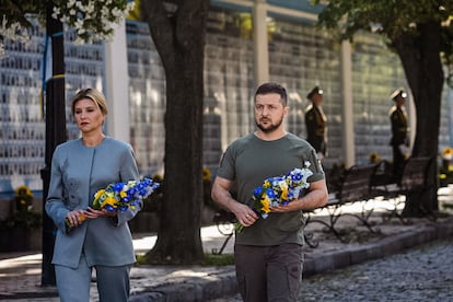 This handout photo taken and released by the Ukrainian presidential press service on August 24, 2022, shows Ukrainian President Volodymyr Zelensky (R) and his wife Olena attending a commemoration ceremony at a memorial wall displaying images of Ukrainian servicemen and servicewomen killed since Russia launched a military invasion on the country in February, in the centre of Kyiv, on Ukraine's Independence Day. - Ukraine's Independence Day also marks six months since the start of Moscow's military invasion launched on February 24. (Photo by UKRAINE PRESIDENCY / AFP) / RESTRICTED TO EDITORIAL USE - MANDATORY CREDIT "AFP PHOTO / UKRAINIAN PRESIDENTIAL PRESS SERVICE" - NO MARKETING NO ADVERTISING CAMPAIGNS - DISTRIBUTED AS A SERVICE TO CLIENTS