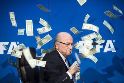 Un cómico lanza billetes a Blatter. En la imagen, el presidente de la FIFA pide ayuda a su seguridad.