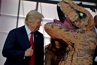 Donald Trump felicita a un niño disfrazado de dinosaurio durante la fiesta de Halloween.