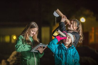 Unas niñas utilizan el telescopio casero para contar las estrellas en Suecia. 