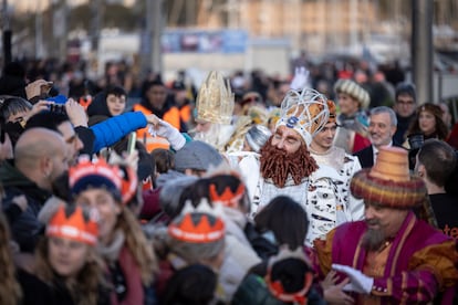 El Rey Gaspar (en primer plano) y el Rey Baltasar, junto a sus pajes, saludan a los niños a su llegada a Barcelona.