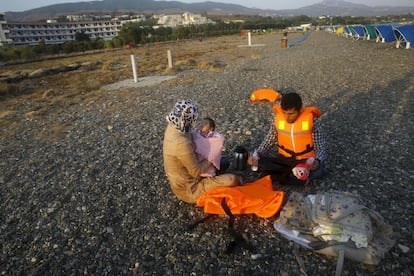 Los refugiados Mohamed y Kawsr preparan el biberón a su hija de dos meses momentos después de llegar a una playa de Kos.