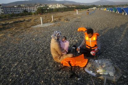 Los refugiados Mohamed y Kawsr preparan el biberón a su hija de dos meses momentos después de llegar a una playa de Kos.