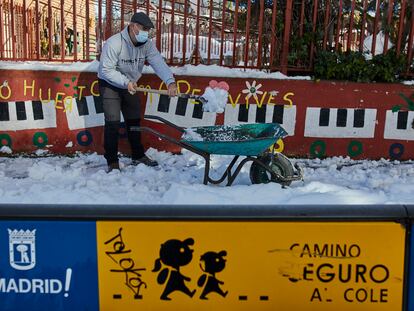 Un familiar colabora en la limpieza del hielo y la nieve en las inmediaciones del colegio Amadeo Vives tras la nevada.