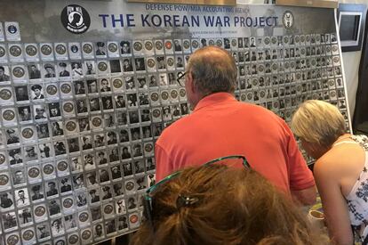 Varios familiares de soldados desaparecidos en la guerra de Corea miran un panel con información durante un evento en Arlington, el 9 de agosto