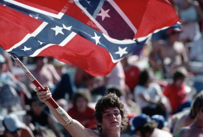 Un joven ondea la bandera confederada en un concierto al aire libre de música country en Oklahoma en 1982