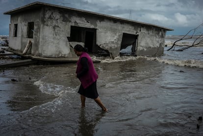 Una mujer camina junto a una casa destruída por el aumento en el nivel del mar, en la colonia El Bosque (Estado de Tabasco), en 2022.