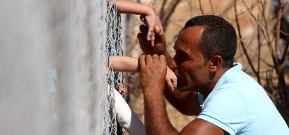 Um homem beija a mão de sua filha em um acampamento de refugiados, em Nicosia (Chipre).