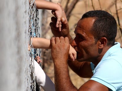 Um homem beija a mão de sua filha em um acampamento de refugiados, em Nicosia (Chipre).