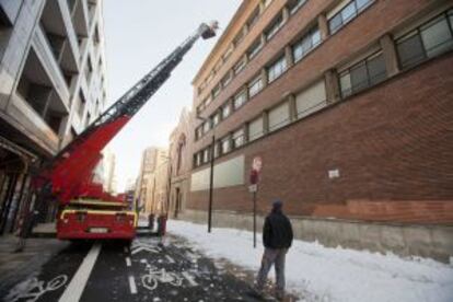 Los bomberos de Vitoria retiran nieve de un tejado del centro de Vitoria, donde ha nevado los últimos cuatro días.