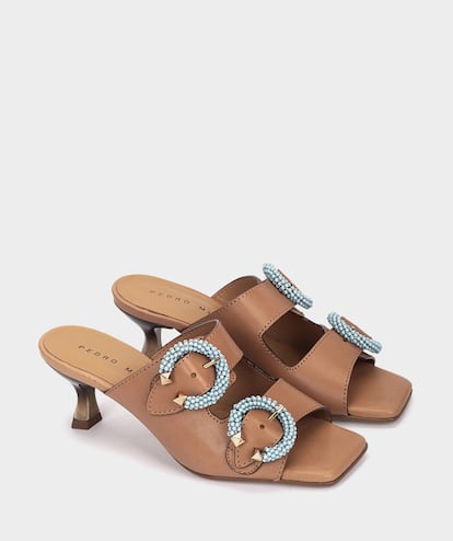 Estas sandalias de Pedro Miralles tienen el tacón justo para elevar unos centímetros sin resultar incómodas para llevar a diario. Sus hebillas de abalorios en azul turquesa son el contrapunto perfecto para el color de caramelo de su piel.
