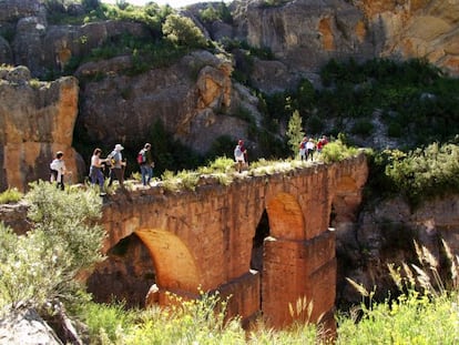 Excursionistas cruzando el acueducto de la Pe&ntilde;a Cortada, de donde cay&oacute; la mujer fallecida, en una imagen de la web del Ayuntamiento de Calles.