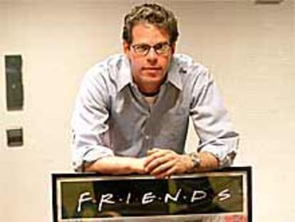 Andrew Reich, junto a un cartel de la serie Friends.