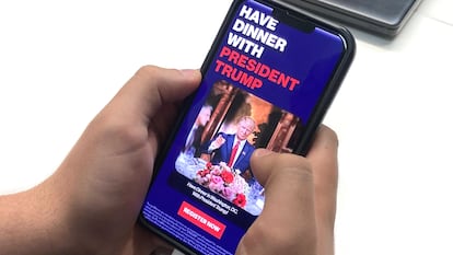 Un joven mira en su móvil un anuncio de los emisores de la memecoin de Trump.