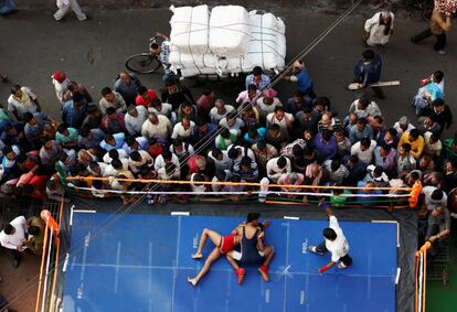 Dos deportistas luchan, en una competición de lucha amateur, en un ring improvisado cerca de un mercado de Calcuta (India). 