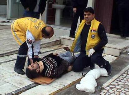 Dos sanitarios atienden a uno de lo heridos en el ataque de ayer contra la editorial cristiana en Malatya.