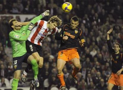 Llorente salta a por el balón entre Guaita y Marchena.