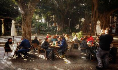 Unos vecinos de Alicante toman un aperitivo en una plaza de la ciudad. 