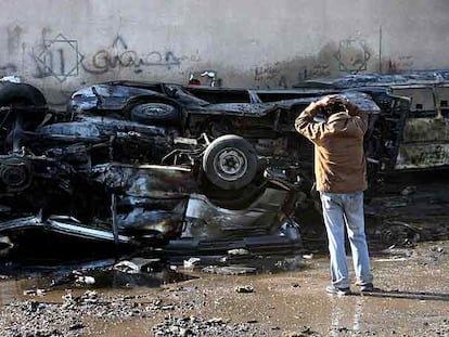 Un iraquí contempla un amasijo de coches destruidos por la explosión de una bomba ayer en Bagdad.