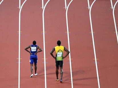 El norteamericano Cristian Coleman (i) y el jamaicano Usain Bolt caminan por la pista tras final de los 100 metros de los mundiales de atletismo de Londres.