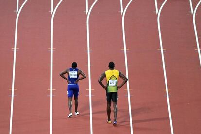 El norteamericano Cristian Coleman (i) y el jamaicano Usain Bolt caminan por la pista tras final de los 100 metros de los mundiales de atletismo de Londres.