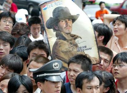 Jóvenes chinos sostienen un póster de David Beckham, en una imagen fechada en 2003.