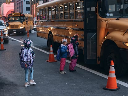 Niños migrantes toman un autobús escolar frente a su refugio en el Hotel Row, en Nueva York