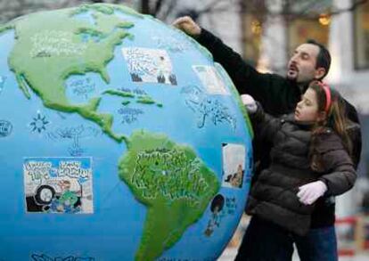 Un niña mira un globo terraqueo en Copenhague durante la conferencia del clima celebrado en dicha ciudad en 2009.