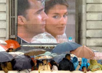 Un corro de verdaderos entusiastas rodea, paraguas en mano, una de las cuatro pantallas gigantes colocadas en la plaza.