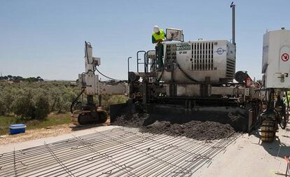 Una m&aacute;quina de la constructora Sando extiende hormig&oacute;n durante las obras de la variante de Marchena (Sevilla).