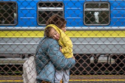 A Ukrainian woman carries her child as they get off a train from Zaporizhzhia at Przemysl train station on September 30, 2022 in Przemysl, Poland