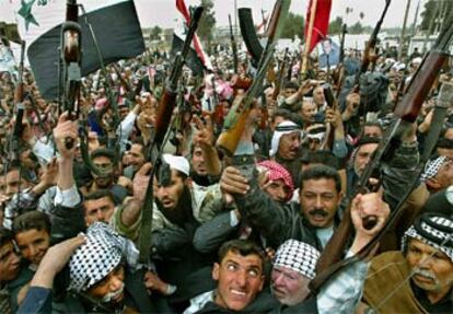 Decenas de hombres  armados protestan por las calles de la ciudad iraquí de Babilonia contra EE UU.