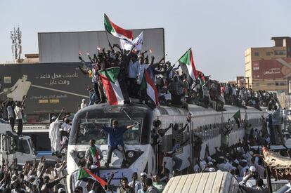 Los manifestantes sudaneses de la ciudad de Atbara, sentados sobre un tren, llegan a la estación Bahari en Jartum el 23 de abril de 2019. Los pasajeros, que habían viajado desde la ciudad de Atbara, donde estalló la primera protesta contra el derrocado presidente Omar al-Bashir el 19 de diciembre, cantaron "libertad, paz, justicia". Muchos manifestantes se sentaron en el techo del tren y ondearon banderas de Sudán mientras recorría la estación de trenes Bahari, en el norte de Jartum, antes de llegar al lugar de la protesta.