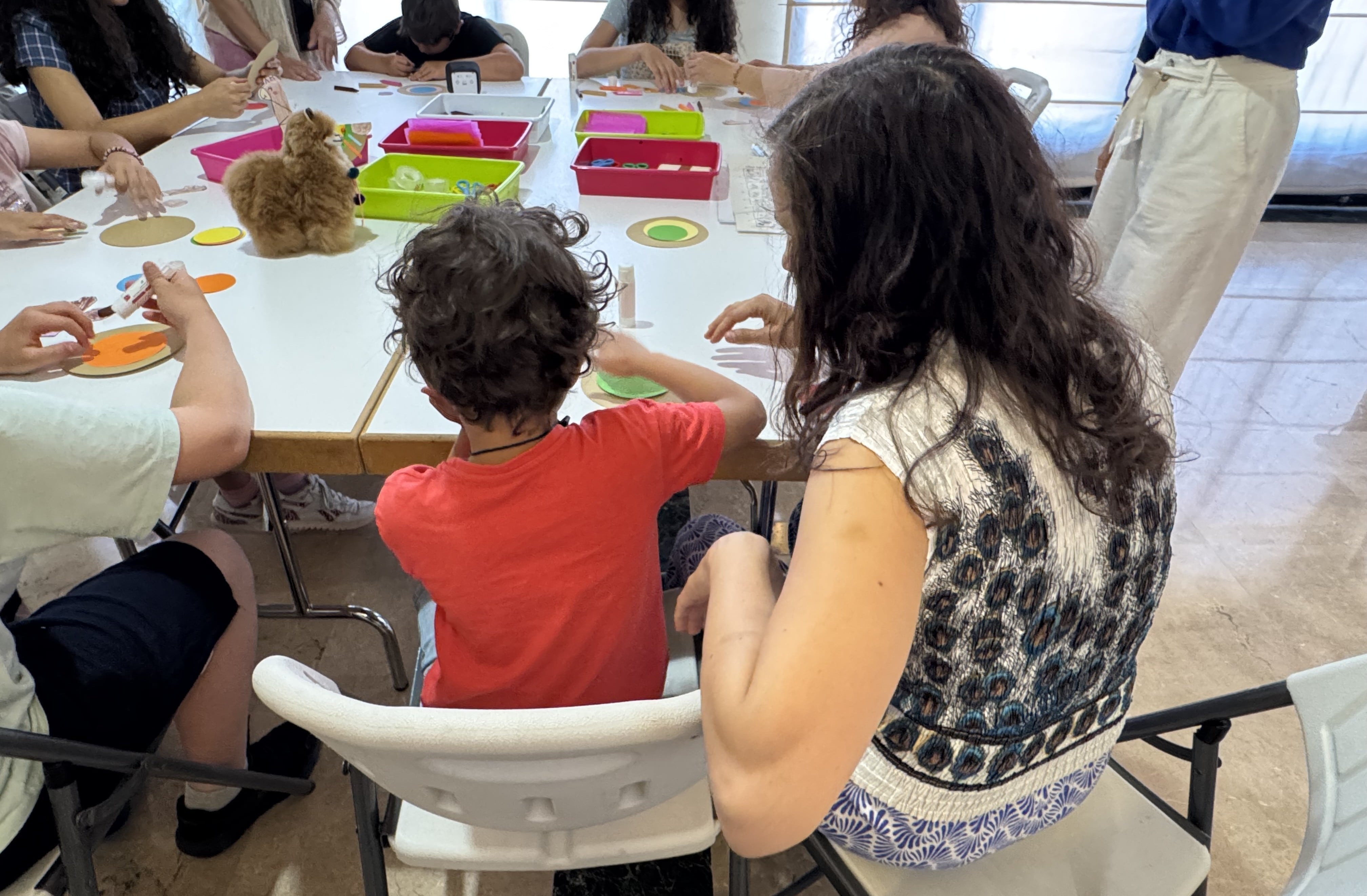 Niños con TEA crean una llama en un taller de manualidades del Museo de América, en Madrid, en compañía de sus padres.