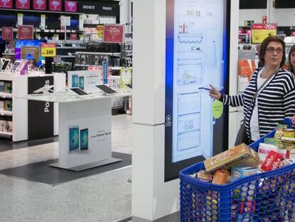 Una pareja compra electrodomesticos en la zona de nuevas tecnologias del centro comercial de Carrefour mientras hacen la compra de la semana. El Prat de Llobregat, 8 de abril de 2016 [ALBERT GARCIA]