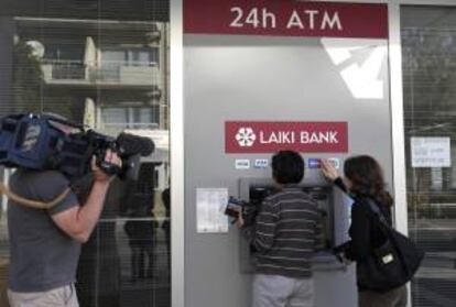 Un cámara graba a dos personas haciendo uso de un cajero automático de una sucursal del banco Laiki, en Nicosia, Chipre. EFE/Archivo