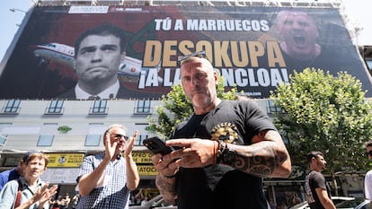 El líder de Desokupa, Daniel Esteve, frente a la lona desplegada en Atocha contra el presidente del Gobierno.