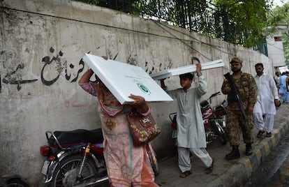 Oficiales custodian a varias personas que transportan material electoral, en Lahore, el 24 de julio de 2018. 