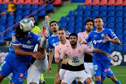 Olivera cabecea un balón ante la defensa del Espanyol.