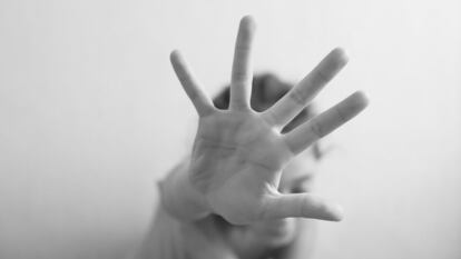 Little girl is protected by an open palm isolated