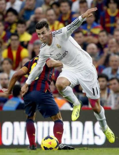 Bale lucha por un balón con Xavi.