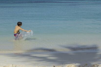 Un niño juega en una playa de Aruba.