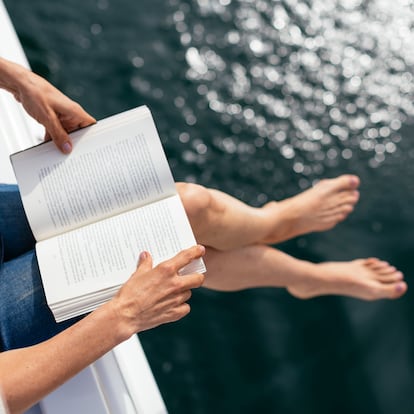 Woman sitting on sailing boat, reading a book