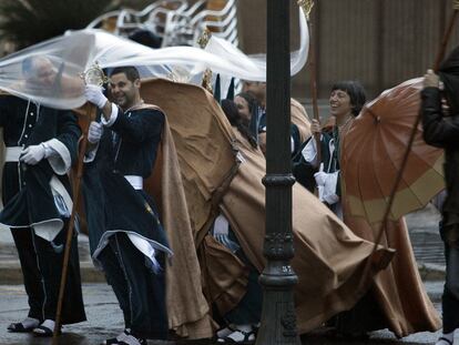 Una hermandad de la procesión marinera de El Cabanyal de Valencia se retira, obligada por la lluvia, nada más comenzar la procesión de Jueves Santo.